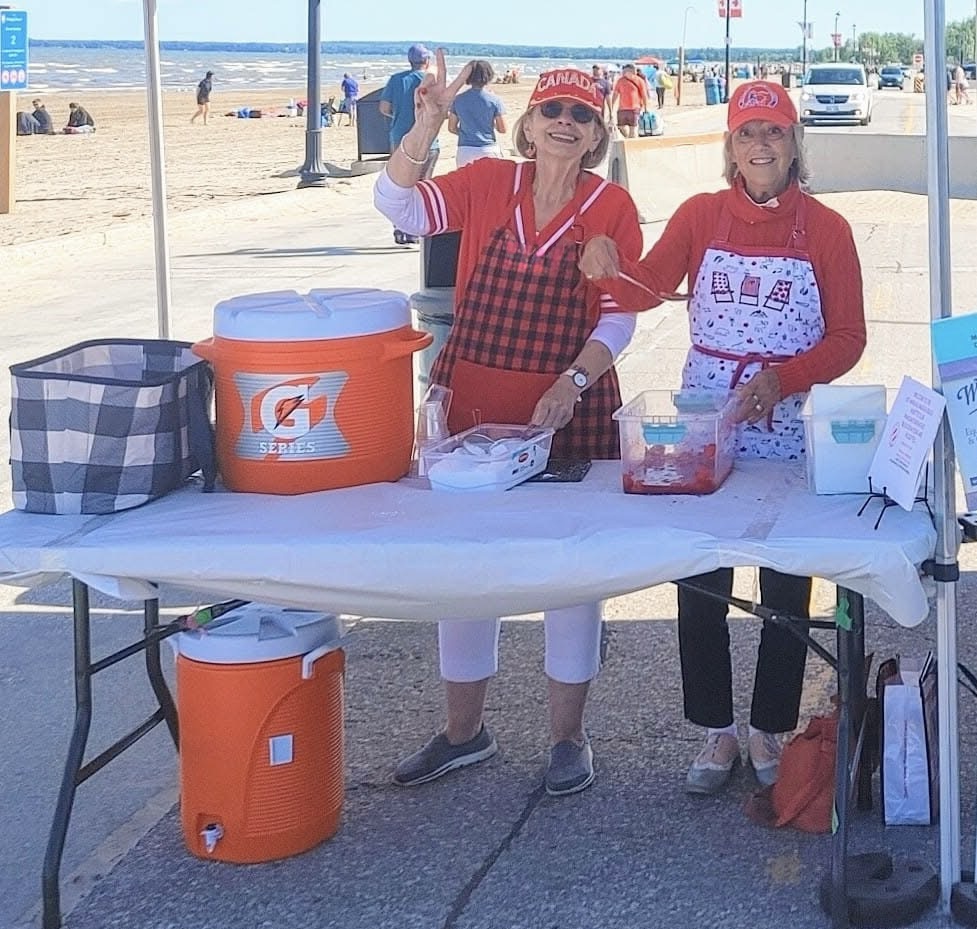 Ellen Timms volunteering with a community member at a Canada Day event on the beachfront